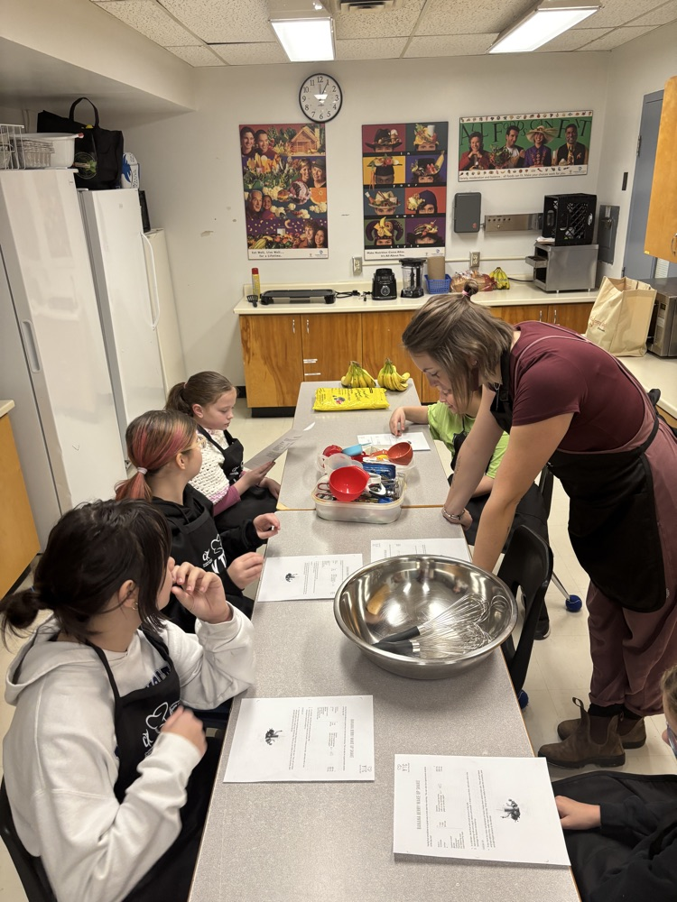 students reading a recipe in a kitchen