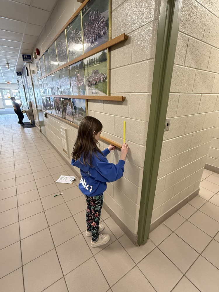 Grade 4 female student measuring a board on a wall for an angle