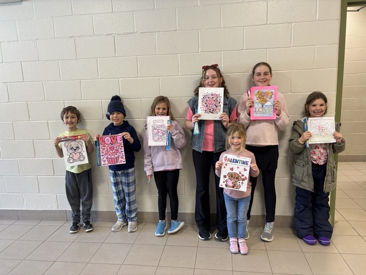 seven students standing smiling at the camera with their winning colouring contest pages