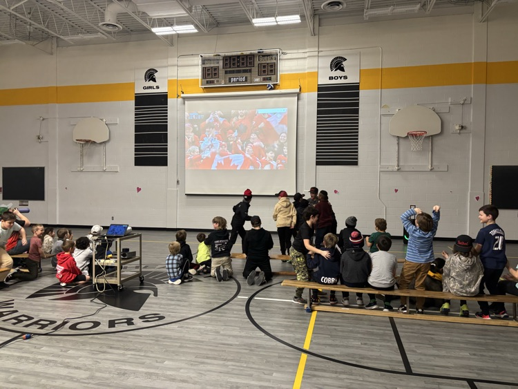 students in the gym watching the hockey game