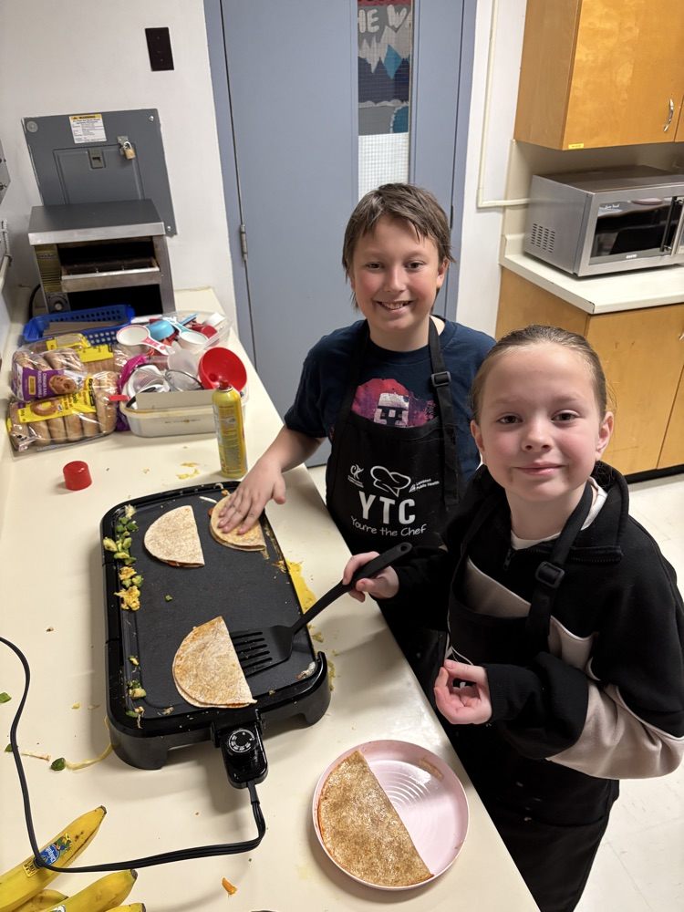 Students cooking quesadillas on a grill