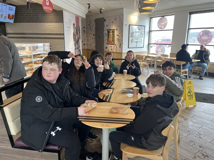 Students sitting having coffee and donuts at the local coffee shop