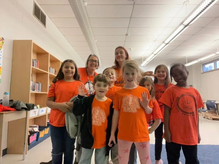 group of students and staff wearing orange shirts 
