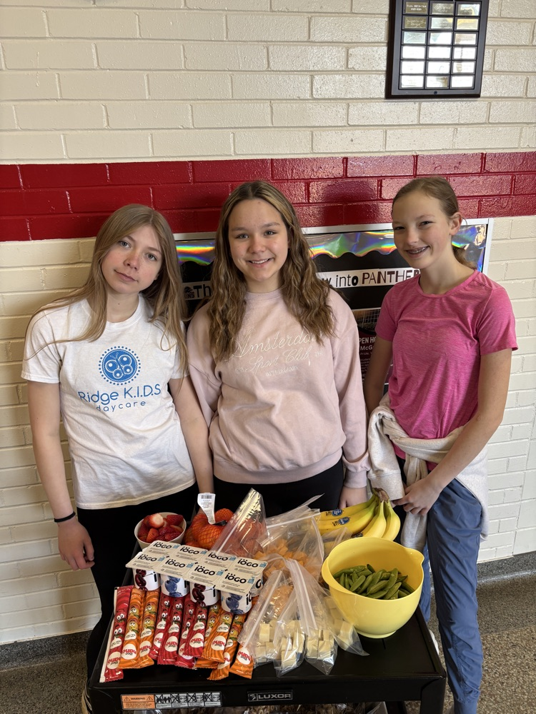 students in front of a cart filled with snacks