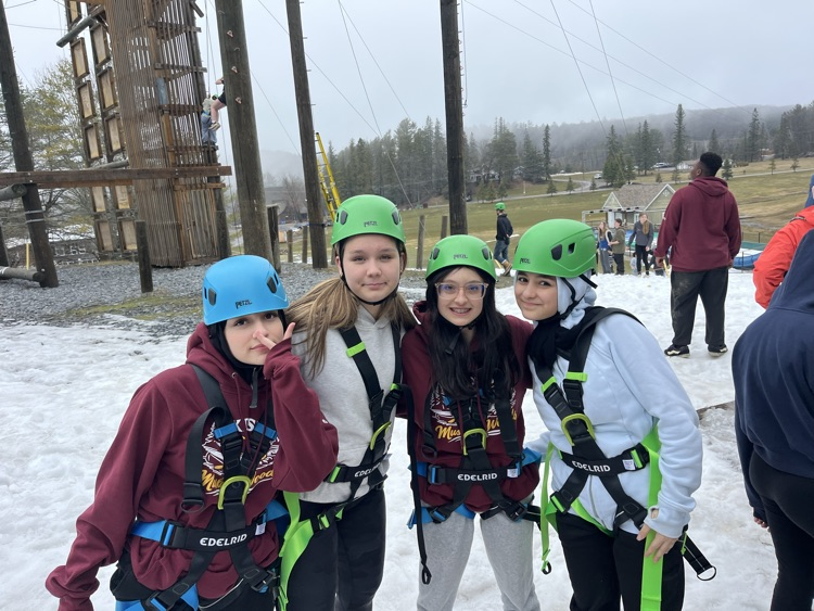 Students at high ropes course with helmets and safety