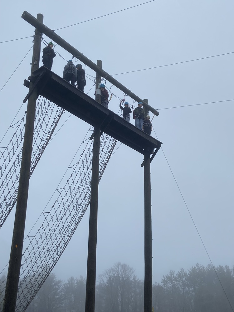 Students on a high rope course giant swing