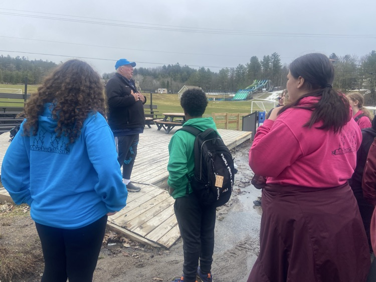 Student standing out by a lake