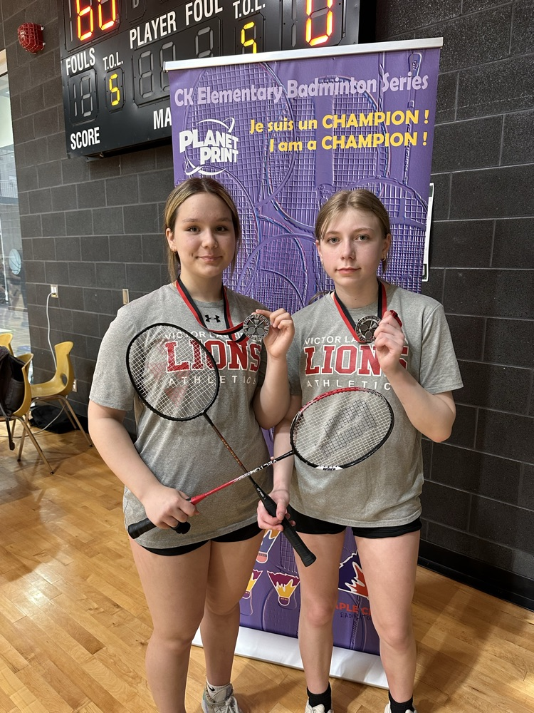 girls doubles badminton team with silver medals 