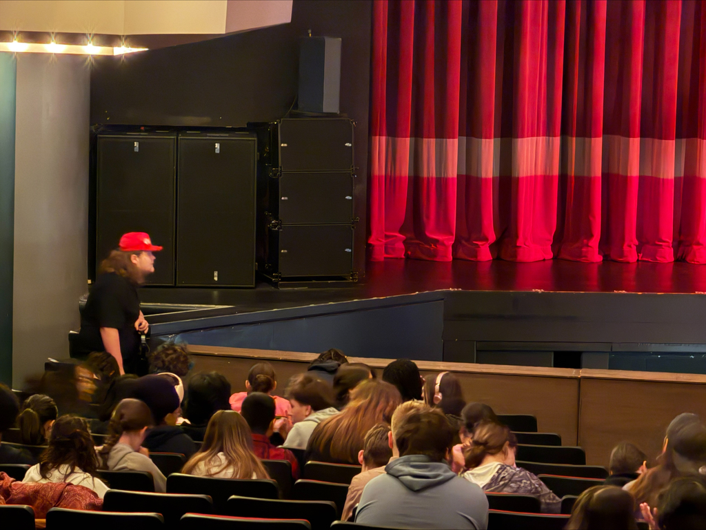 Students seated at the theatre, waiting for the show to begin.