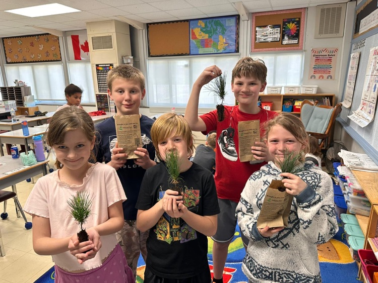 Students holding tree saplings