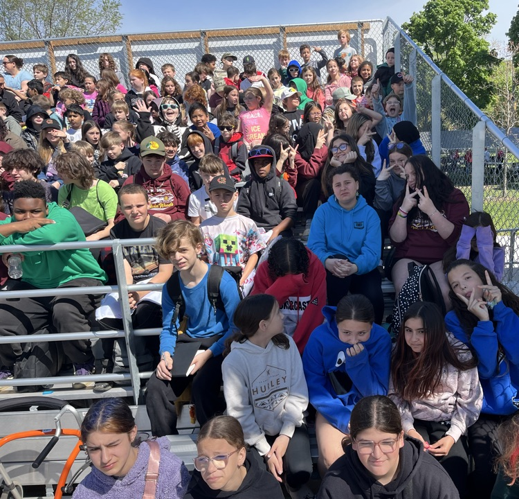student sitting in bleachers watching a baseball game