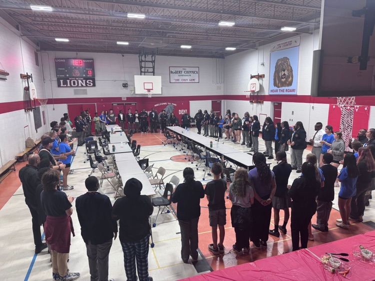 students from two schools creating a circle around the gym