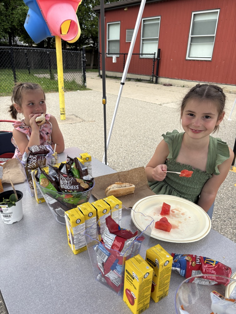 two children eating a picnic at a table