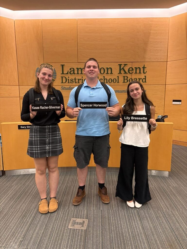 Student Trustees pose with their name and gifted backpacks on their final board meeting.
