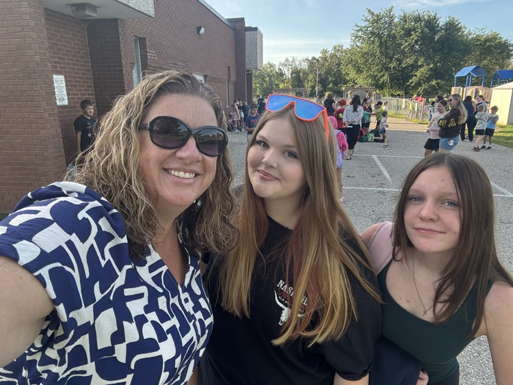 two grade 8 girls smiling at the camera with Mrs V