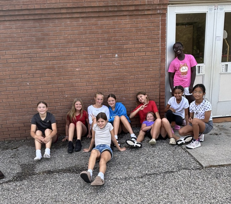 Group of girls sitting on the pavement at recess