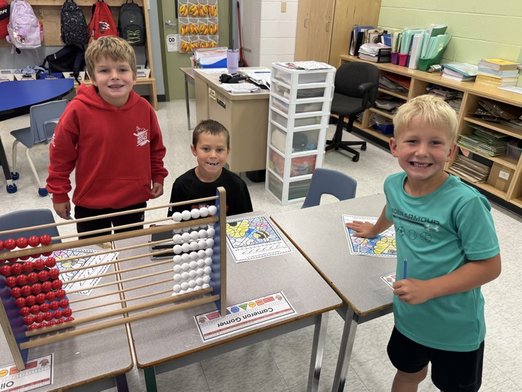 Grade 1/2 boys completing a math activity with a large Rekenrek to help them