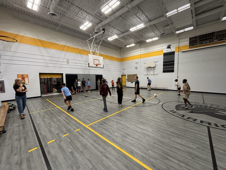 Boys running soccer drills in the gym for tryouts