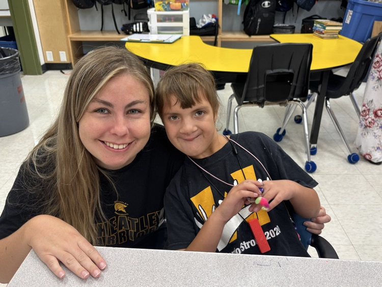 Ms Boakes and student smiling at the camera with their Warrior shirts on