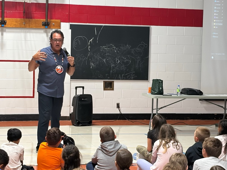 Jason Simon speaking to a gym full of students