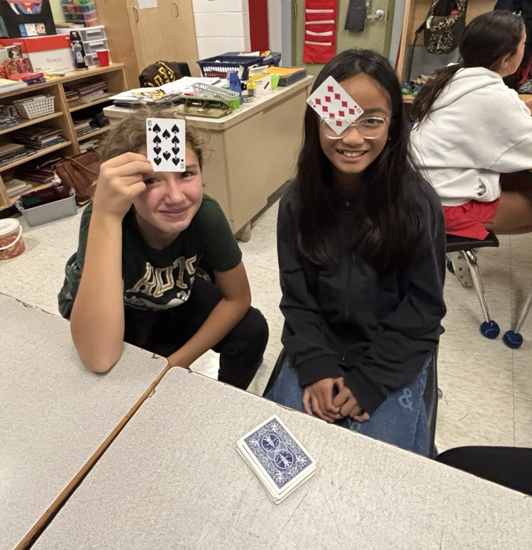 two girls playing a math card game