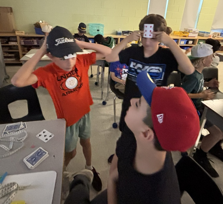 three boys playing a math card game
