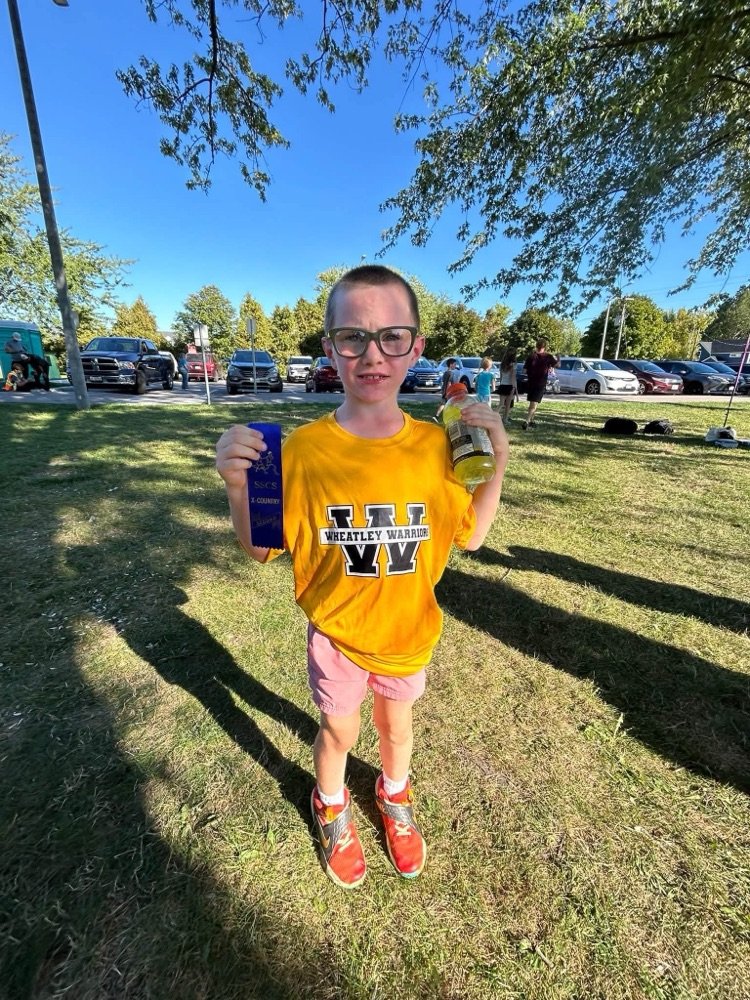 Young Wheatley warrior holding his ribbon after his race