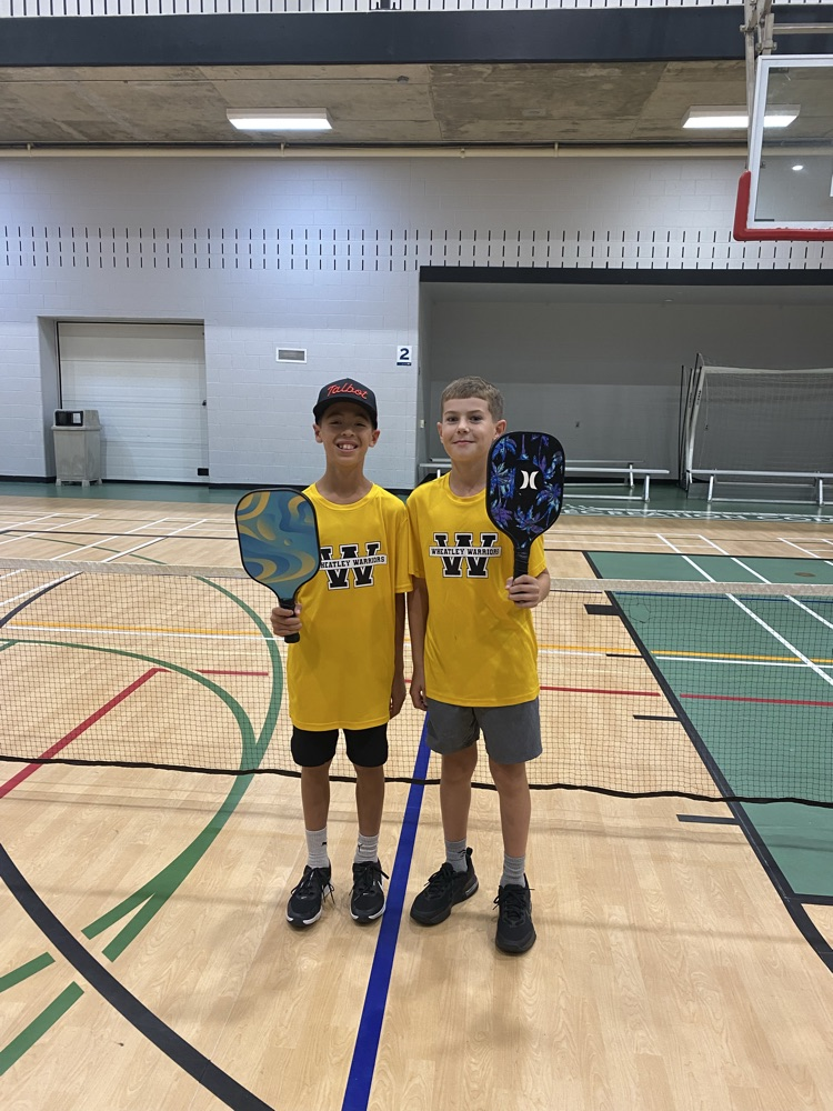2 male pickleball players with their paddles