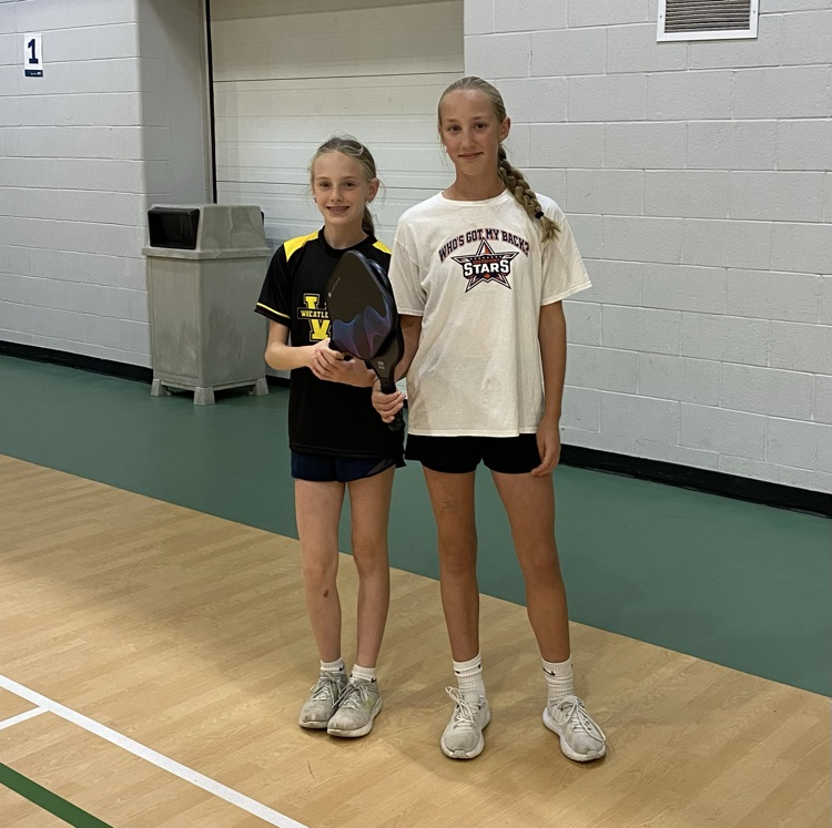two female pickleball players with their paddles