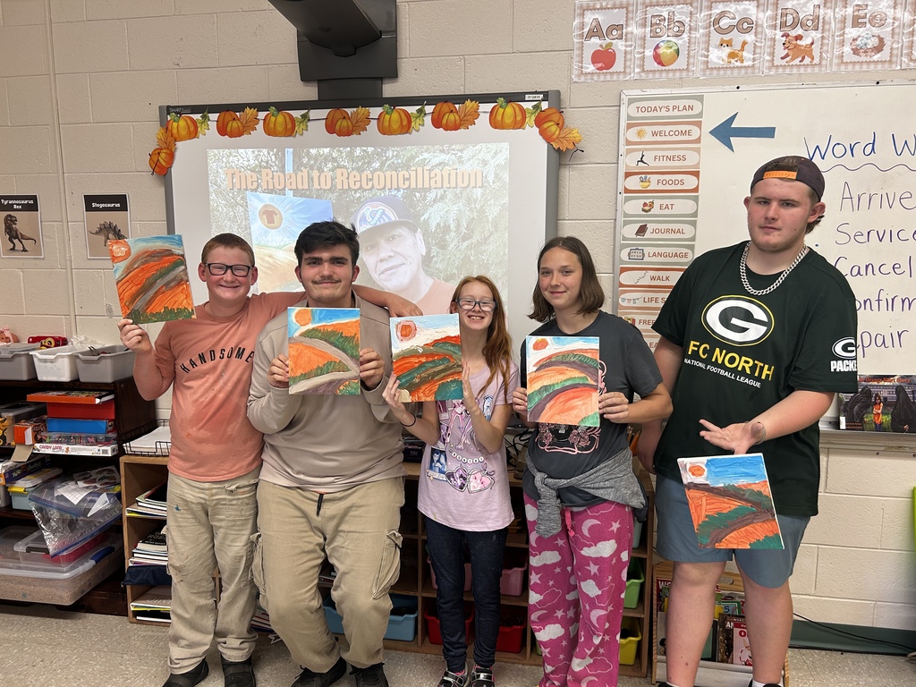 Students show off the artwork they created with Moses.