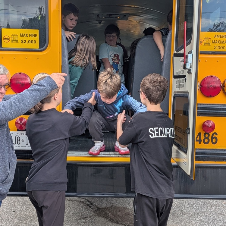 students practicing bus evacuation through emergency exit