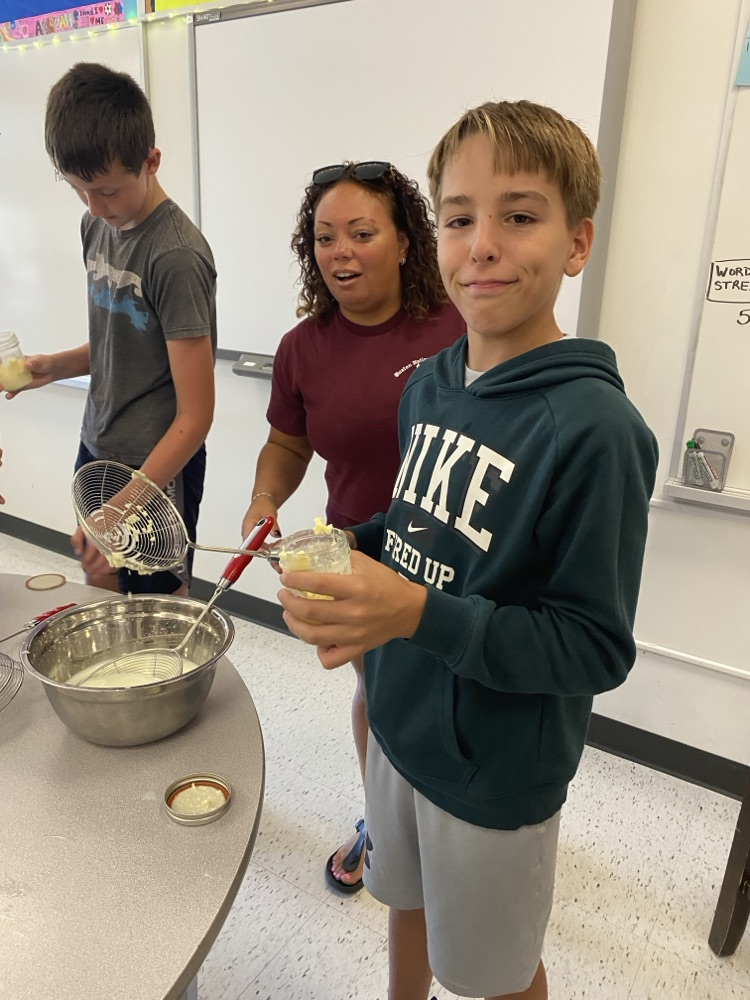 Student holding ingredients needed to make butter.