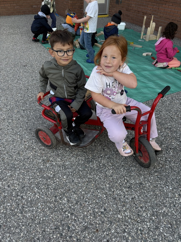 two FDK students on a bike outside