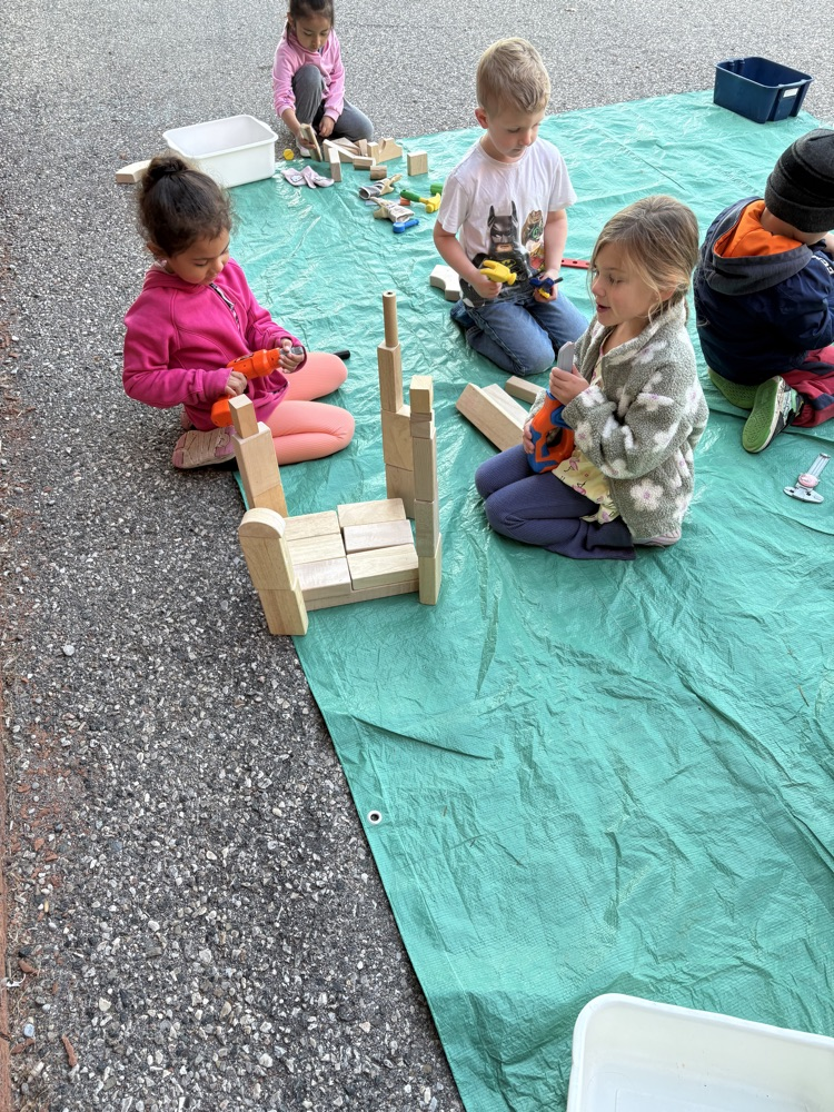 2 FDK students building on a green tarp with blocks 