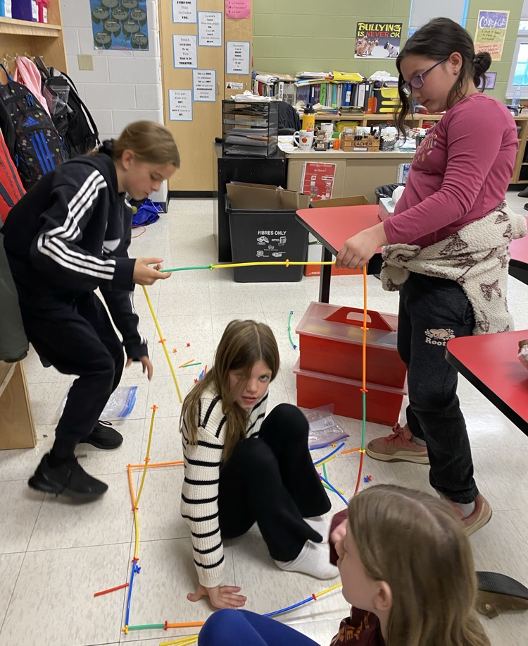 4 girls using straws and connectors in the build a house challenge