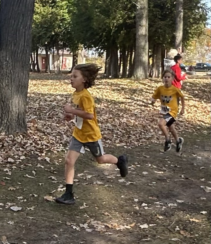 two junior boys cross country runners running on the course