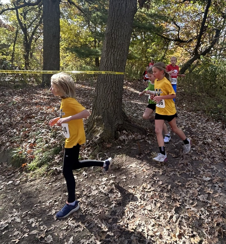 two junior cross-country runners running on their course