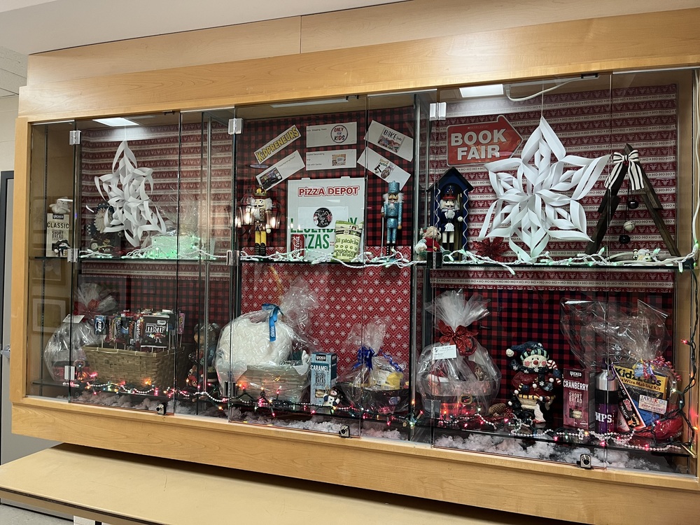 front foyer with holiday craft fair baskets and holiday decoration items with red and white wrapping paper in background. 