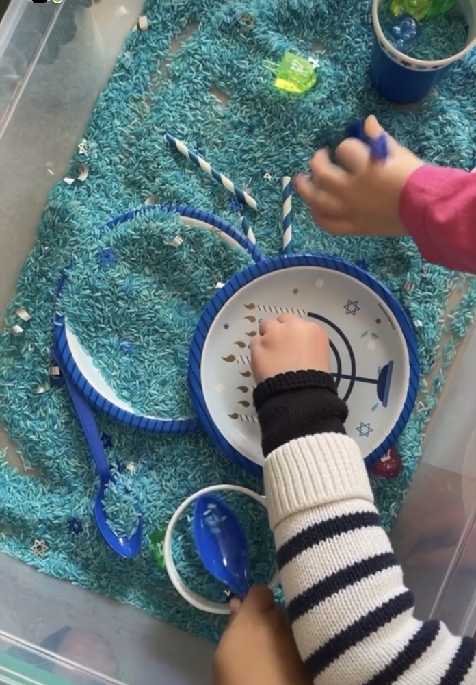 Children playing blue rich with very sensory items, spoons, plates. Hanuakah themed. Lots of blue.