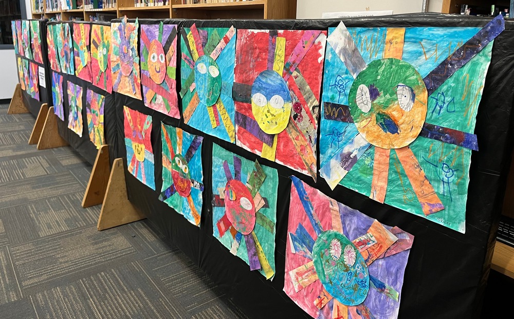 Various suns in multiple colours made by kindergartens- lots of different colours with rays from the sun shooting out.