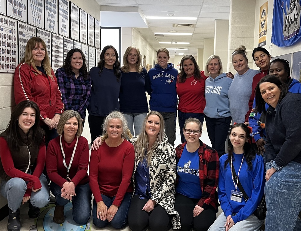 Staff picture of teachers wearing red and blue in school hallway on Autism Awareness Day