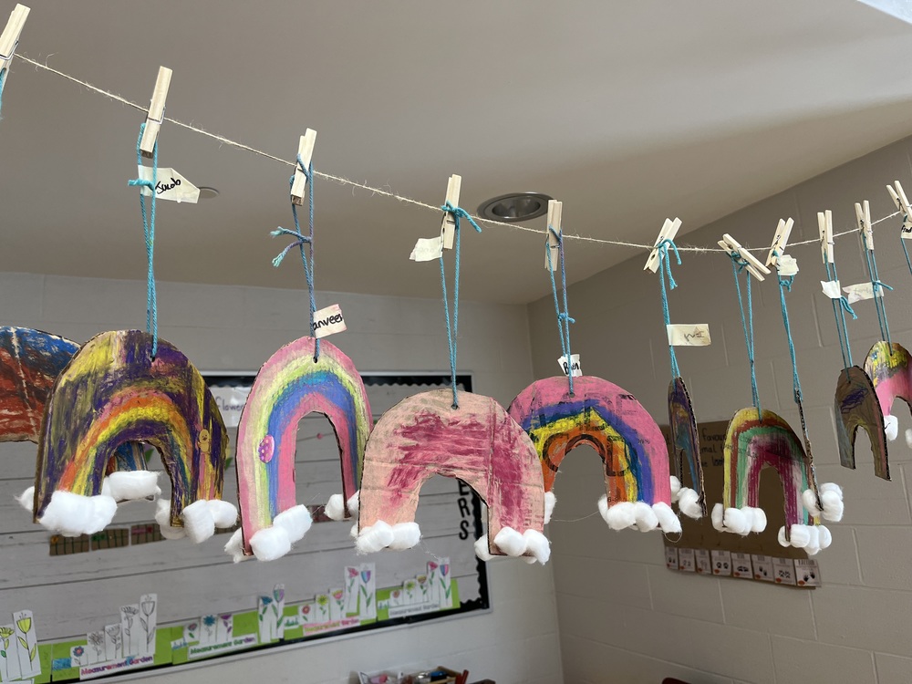 Mini rainbows hanging with lots of colours and cotton balls for clouds.