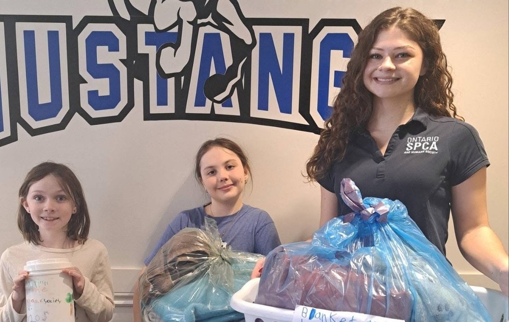Picture of two girls a young woman holding blankets .