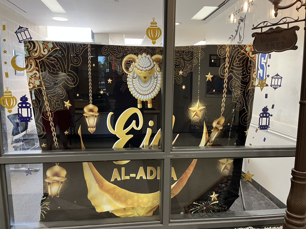 Happy Eid! Dark black banner with a sheep and moon, gold lanterns 