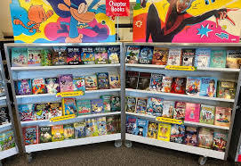 Colourful selection of childrens' books on open shelf. 