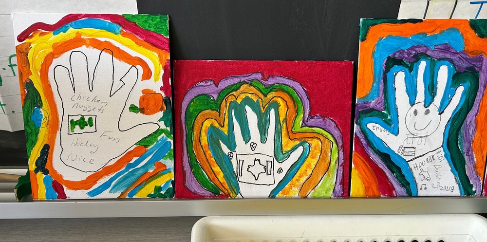 3 hand prints with carious bright colours that outline them and images inside the hand that are important to children including the Canadian flag.