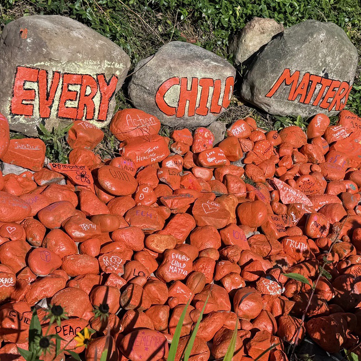 rocks painted orange and the words 'every child matters'