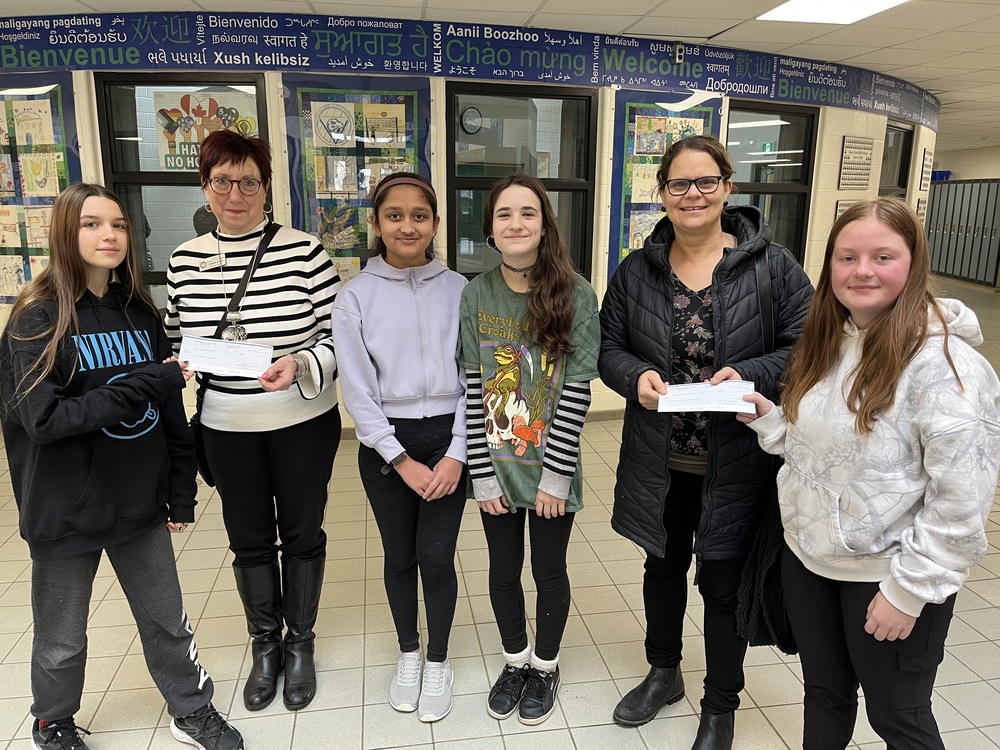 A photo of 4 TEPS students with representatives from the food banks
