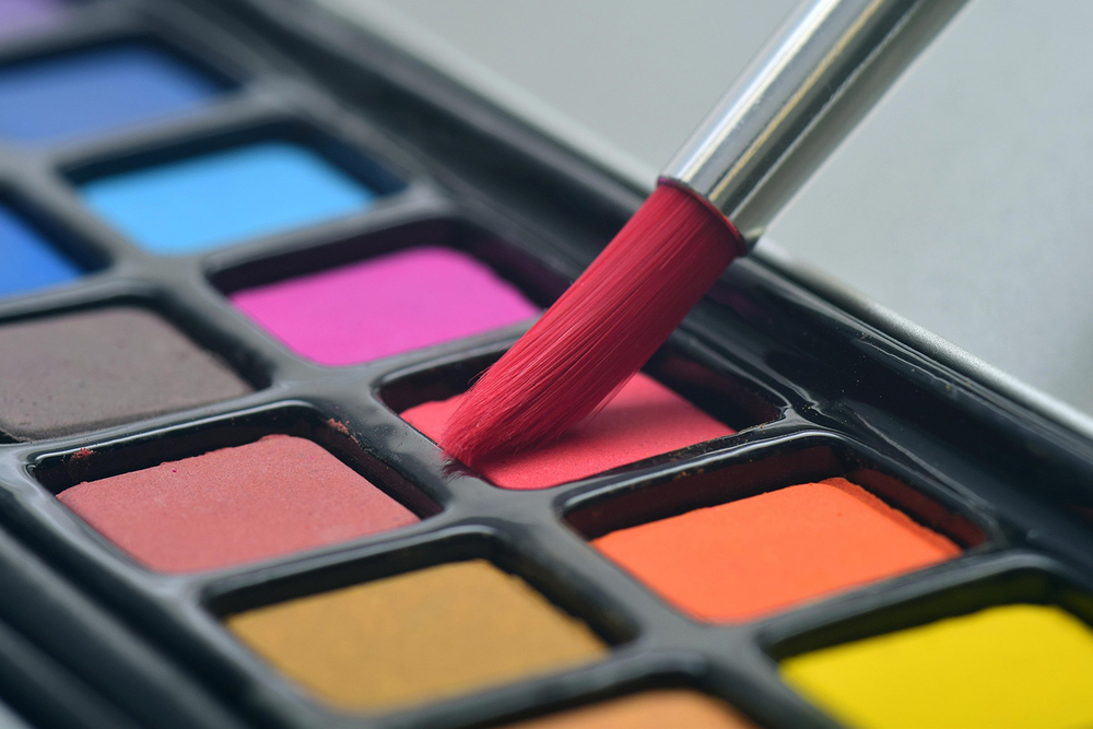 Close-up photograph of water colour paints and a paint brush