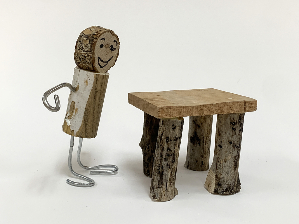 A toy person and table made from scrap materials.